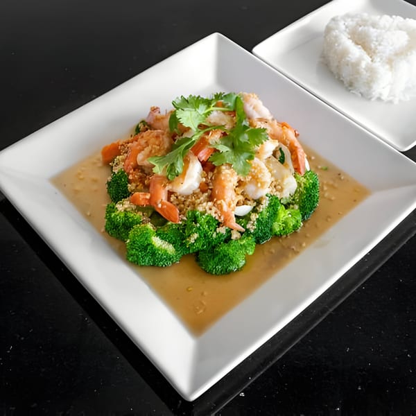 Thai shrimp and broccoli stir-fry with sauce and cilantro, served with a side of white rice.