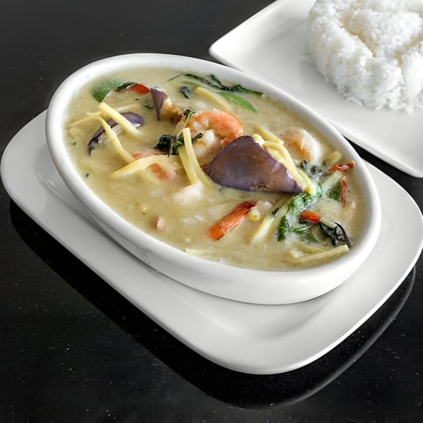 Thai green curry with shrimp, eggplant, and bamboo shoots, served with a side of white rice.